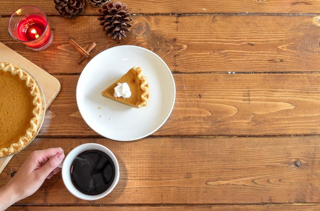 Slice of pumpkin pie with cup of coffee