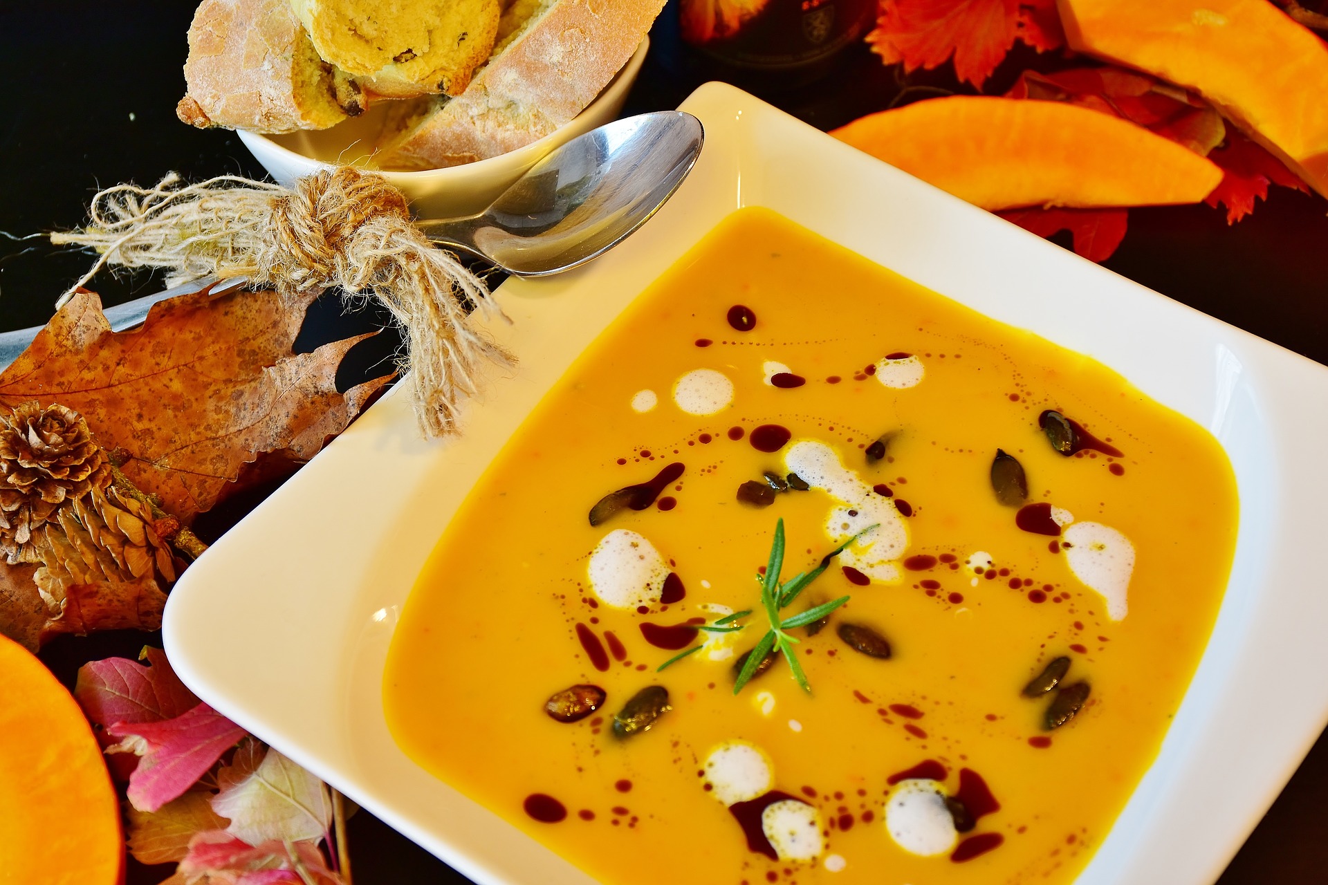 Bowl of butternut squash soup with white and dark red garnishes